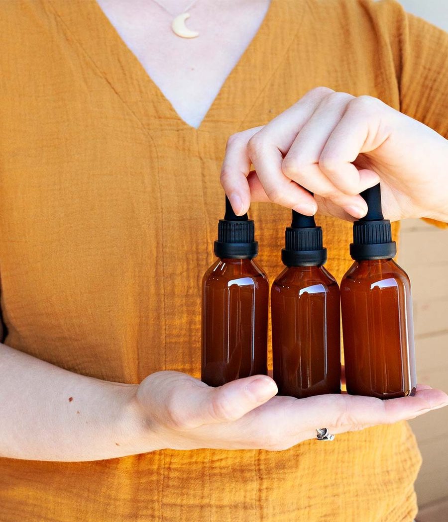 Three amber dropper bottles held in two hands