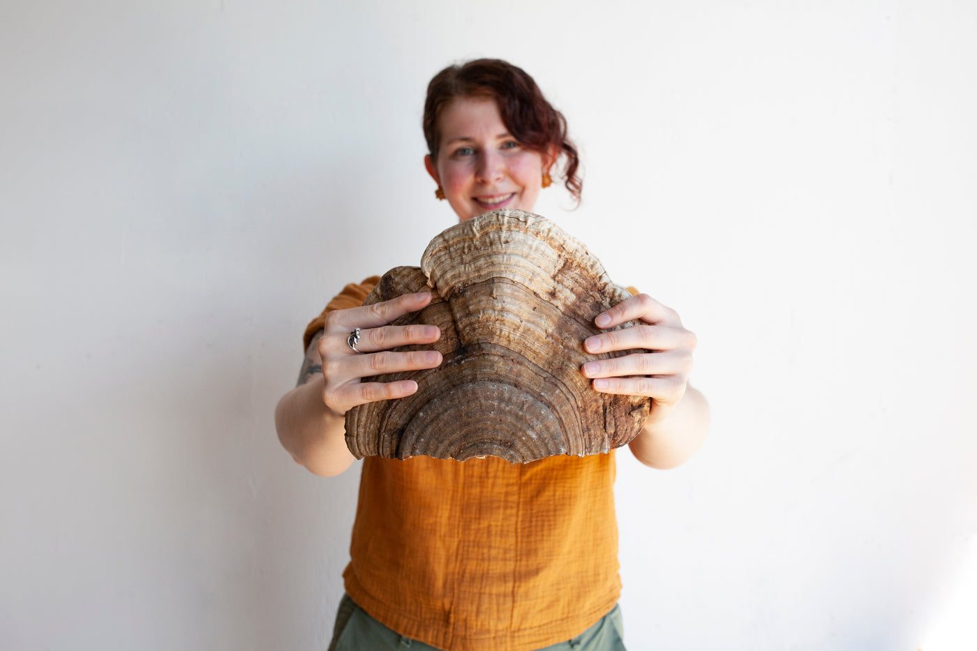Team member holding a large shelf mushroom